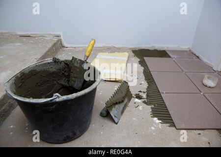 Ein Kunststoff Eimer mit Zement Klebstoff bereit zum Verkleben von keramischen Fliesen verwendet werden. Stockfoto