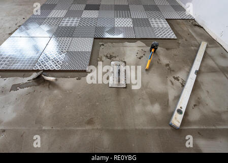 Keramische Fliesen und Werkzeuge für Fliesenleger. Bodenfliesen Installation. Stockfoto