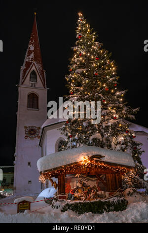 SEEFELD, Österreich - Januar 07, 2019: Nachtansicht von St. Oswald Pfarrkirche in Seefeld in Tirol mit einem riesigen schneebedeckten Christus Stockfoto