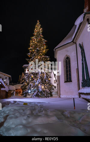SEEFELD, Österreich - Januar 07, 2019: Nachtansicht von St. Oswald Pfarrkirche in Seefeld in Tirol mit einem riesigen schneebedeckten Christus Stockfoto