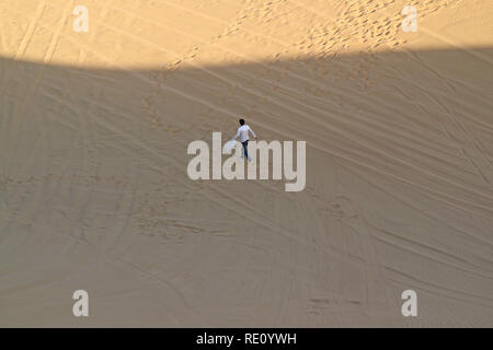 Mann mit seinem Sand Board gehen auf Huacachina Wüste, ICA-Region, Peru, Südamerika Stockfoto