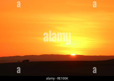 Unglaubliche Sonnenuntergang über den Sanddünen von Huacachina Wüste mit der Silhouette der Touristen Dune Buggy, ICA-Region, Peru Stockfoto