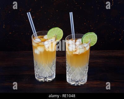 Dark'n'stürmisch, einen Cocktail aus dunkler Rum, Ginger Ale oder Bier, in einem highball Glas gefüllt mit Eis serviert, garniert mit einer Scheibe Limette Stockfoto