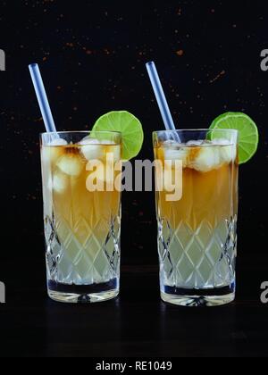 Dark'n'stürmisch, einen Cocktail aus dunkler Rum, Ginger Ale oder Bier, in einem highball Glas gefüllt mit Eis serviert, garniert mit einer Scheibe Limette Stockfoto