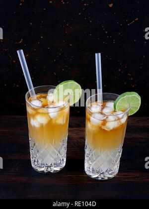 Dark'n'stürmisch, einen Cocktail aus dunkler Rum, Ginger Ale oder Bier, in einem highball Glas gefüllt mit Eis serviert, garniert mit einer Scheibe Limette Stockfoto