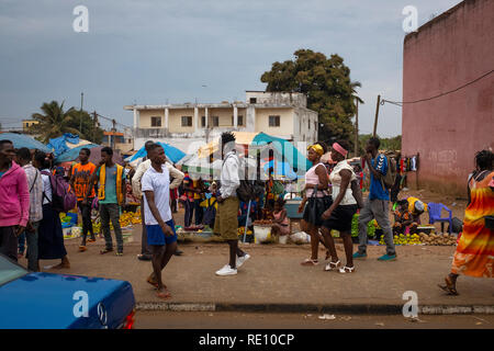 Bissau, Republik Guinea-Bissau - Februar 6, 2018: Street Scene in der Stadt Bissau mit Menschen zu Fuß auf einem Bürgersteig in der Nähe einer Straße, Markt, in Gu Stockfoto