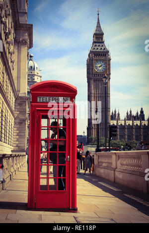 Ein Mann mit dem Telefon in einem typischen britischen Telefonzelle auf dem Bürgersteig mit dem berühmten Elizabeth Tower (Big Ben) im Hintergrund - London, Großbritannien Stockfoto