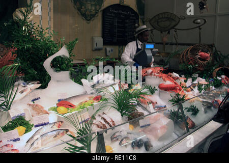 Verkäufer hinter der Showcase mit frischem Fisch und Meeresfrüchte im Kaufhaus Harrods in London, Vereinigtes Königreich Stockfoto