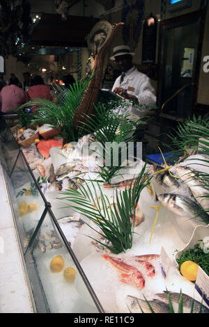 Verkäufer hinter der Showcase mit frischem Fisch und Meeresfrüchte im Kaufhaus Harrods in London, Vereinigtes Königreich Stockfoto