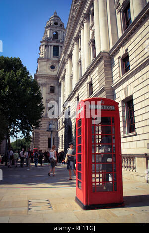 Typisch britische Telefonzelle auf dem Bürgersteig vor den staatlichen Ämtern Great George Street (GOGGS) Gebäude in London, Vereinigtes Königreich Stockfoto