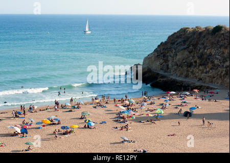 Sonnenanbeter am Sandstrand Praia do Túnel, Albufeira, Algarve, Portugal Stockfoto