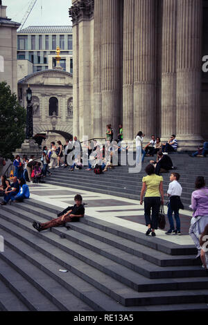 Menschen sitzen und entspannen auf den Treppen des Royal Exchange in London, Vereinigtes Königreich Stockfoto