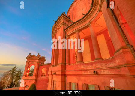 Seitenansicht der Fassade des Heiligtums der Madonna di San Luca und Arkaden von seiner langen Portikus mit Licht des Sonnenuntergangs. Die Kirche der Jungfrau von San Luca ist ein Wallfahrtsort. Stockfoto