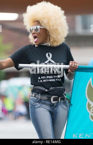 Louisville, Kentucky, USA - Mai 03, 2018: Die Pegasus Parade, afrikanische amerikanische Frau mit blonden Haaren und einem T-Shirt, dass sagt, Held, eine helfende Hand ist ein Stockfoto