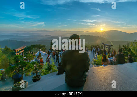 Der Mann sieht den Sonnenaufgang vor der Pforte des Tempels, im Winter morgens, die viele Besucher anzieht, Wochenende Touren Stockfoto