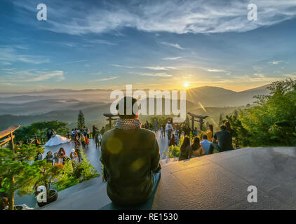 Der Mann sieht den Sonnenaufgang vor der Pforte des Tempels, im Winter morgens, die viele Besucher anzieht, Wochenende Touren Stockfoto