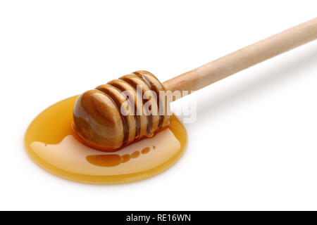 Holzstab im Honig Pfütze auf weißem Hintergrund Stockfoto