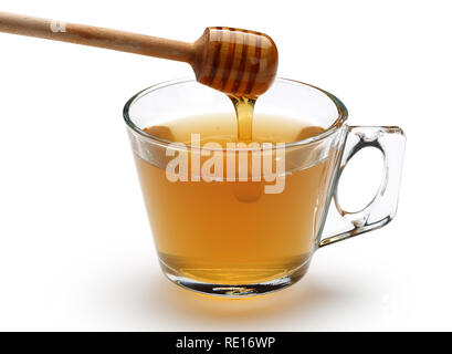 Honig gießen aus Holz Pendelarm in eine Tasse linden Tee auf weißem Hintergrund Stockfoto
