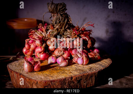 Stillleben mit Schalotten - rote Zwiebeln auf hölzernen Tisch. Stockfoto