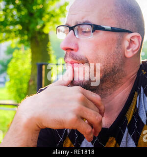 Der Mann mit der Brille leidet unter Depressionen. Probleme im persönlichen Leben und bei der Arbeit. Stress und Depressionen. Migräne ist eine Folge von Stress. Stockfoto