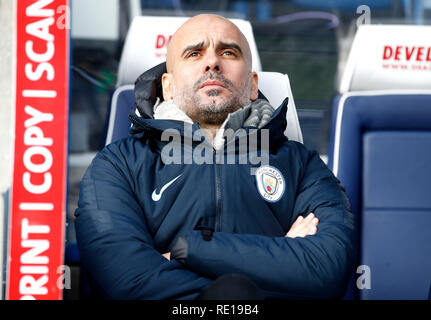 Manchester City Manager Pep Guardiola sitzt auf der Bank vor der Premier League match Am John Smith's Stadion, Huddersfield. Stockfoto