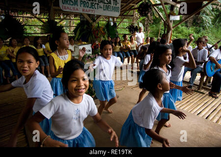 Einige Kinder singen und tanzen am Rande des Loboc River, wenn Touristen kommen, während Sie eine Bootsfahrt unternehmen. Loboc Bohol Philippinen Stockfoto