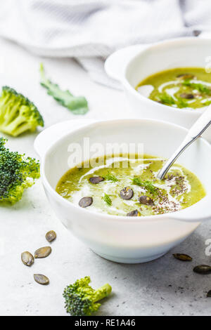 Vegan detox Broccoli creme Suppe mit Kokosmilch und Kürbiskerne in einer weißen Schüssel. Auf Basis pflanzlicher Nahrung Konzept. Stockfoto