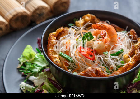 Schwarze Schale mit Thai Omelette, Reis, Nudel und Garnelen Stockfoto