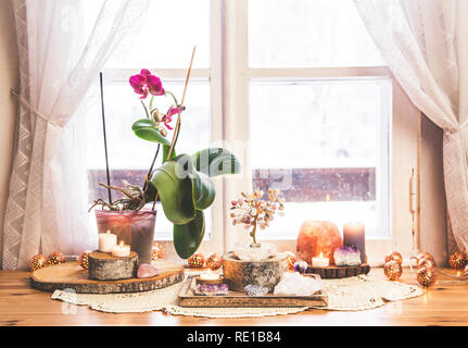 Feng Shui Thema Natur Altar zu Hause Tisch und auf der Fensterbank. Element Erde (Rock crystal Cluster), Holz (Holz-Scheiben), Element Feuer (Kerzen Stockfoto