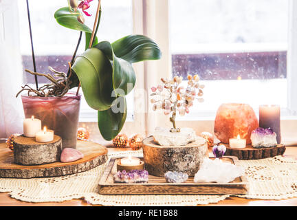 Feng Shui Thema Natur Altar zu Hause Tisch und auf der Fensterbank. Element Erde (Rock crystal Cluster), Holz (Holz-Scheiben), Element Feuer (Kerzen Stockfoto