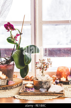 Feng Shui Thema Natur Altar zu Hause Tisch und auf der Fensterbank. Element Erde (Rock crystal Cluster), Holz (Holz-Scheiben), Element Feuer (Kerzen Stockfoto