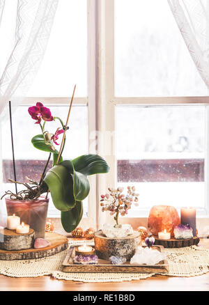 Feng Shui Thema Natur Altar zu Hause Tisch und auf der Fensterbank. Element Erde (Rock crystal Cluster), Holz (Holz-Scheiben), Element Feuer (Kerzen Stockfoto