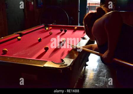 Junge Frau spielen Pool im Saloon Bar Stockfoto