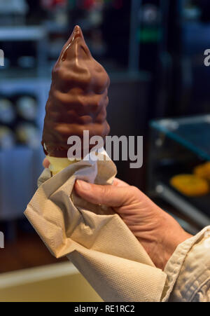 Person, die einen großen Schokolade Eis bedeckt Stockfoto