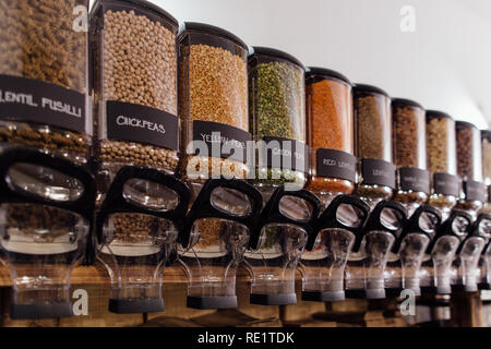 Seitenansicht von rohen Lebensmitteln in Lebensmittelgeschäft angezeigt. Lebensmittel Shop Interior - Regal mit Gläsern voller Erbsen und Linsen in organischen Shop. Stockfoto