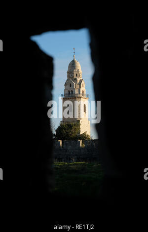 Blick durch Bogenschützen Pfeil Schlupfloch der oberen Sentry Pfad des Osmanischen Wände auf den Glockenturm der Kirche der Benediktinerabtei 1352 oben auf dem Berg Zion in Jerusalem, Israel Stockfoto