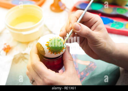 Detail der Frau Malerei ein Osterei mit Pinsel und Wasserfarben. Stockfoto