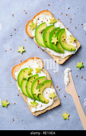 Avocado Toast mit Frischkäse, Leinsamen und Pfeffer, Kreative gesunde Mahlzeit, Ansicht von oben Stockfoto
