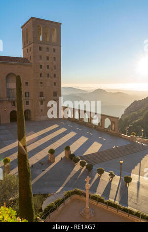 Mit Blick auf das Kloster von Montserrat. Steinstatuen und Bögen auf der Außenseite mit Bergen im Hintergrund in den frühen Morgenstunden. Barcelona, Spanien. Stockfoto