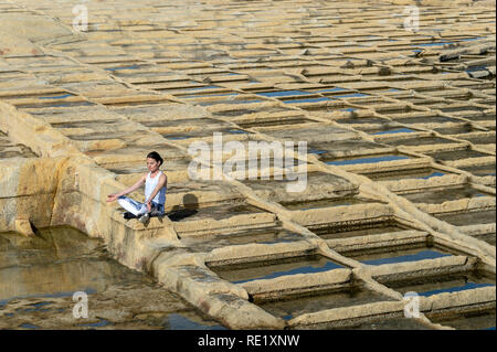 Frau, Meditation, sitzen unter der Kalkstein Salinen in Malta Stockfoto