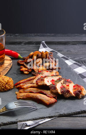 Gebratenes Schweinefilet mit Pilzen und Scheiben Speck mit Pfeffer moonshine serviert. Ungesund aber so lecker Land essen. Stockfoto