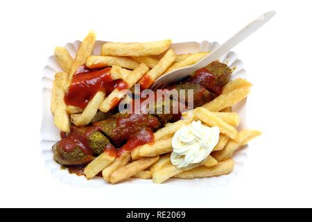 Currywurst mit Pommes Frites, Mayonnaise und Currysauce auf einem Papier Platte, heiße Wurst aus Schweinefleisch Stockfoto