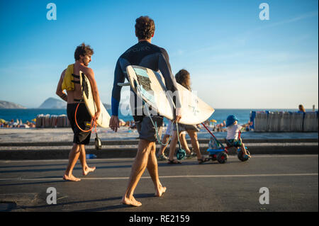 RIO DE JANEIRO - MÄRZ 24, 2017: Ein paar barfüßige junge Surfer Spaziergang auf der Straße mit Surfbrettern auf den Ipanema Beach Boardwalk. Stockfoto