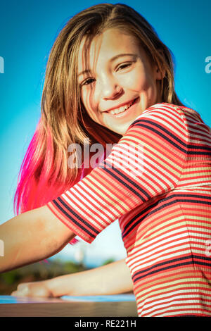 Happy tween mit trendigen rosa Haare lächelt, während sich stützen auf Balkon draußen Stockfoto