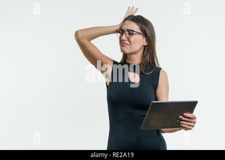 Überrascht business Frau mit einem entsetzten Gesicht hält eine digitale Tablet in der Hand. Plötzliche, unerwartete Rechnerausfall, schockierende Nachrichten, fatal error, Daten Stockfoto