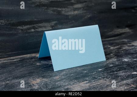 Blaue leere Karte auf dem Tisch. Der dunkle Hintergrund. Stockfoto