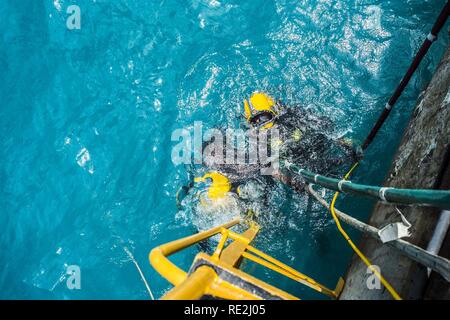 Chief Petty Officer Dan Luberto, rechts, und Petty Officer 2. Klasse Casey Campbell, beide zugeordnet zu Unterwasser Bau Team (UCT) 2 Bau Dive Loslösung Bravo (CDDB), erwarten Anweisungen, um das Wasser zu verlassen, nachdem Sie einen Tauchgang in Diego Garcia, Britisches Territorium im Indischen Ozean, Nov. 10, 2016. CDDB ist die Präzision unter Wasser Abriss und leichten Bergung Sprühbehinderungen von Diego Garcia ist tief Entwurf Wharf zu entfernen. CDDB ist auf der dritten Haltestelle Ihrer Bereitstellung, in dem Sie die Inspektion, Wartung und Reparatur der verschiedenen Unterwasser- und Waterfront Einrichtungen whil Stockfoto