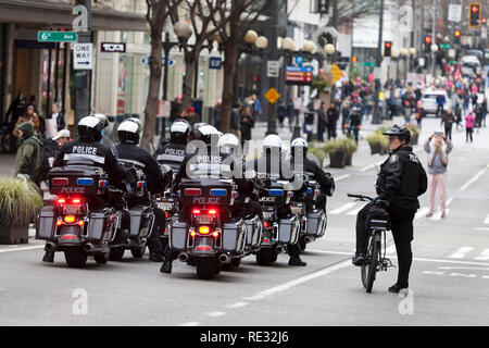 Washington, USA. 19. Jan 2019. Seattle Police Department führt Demonstranten wie in Downtown im März des Womxn Seattle 2019. Samstag im März und Rallye, durch Seattle Womxn marschiert vorwärts in Zusammenarbeit mit MLK Day Veranstalter organisiert, wird gefolgt von einem Tag am Sonntag und Montag MLK Day Veranstaltungen zu Ehren von Martin Luther King Jr.'s Sonntag Womxn Handeln auf Seattle ist eine in der ganzen Stadt Tag der Bildung, Unterstützung, Austausch und im Auftrag der gemeinnützigen Organisationen, Basisorganisationen und soziale Gerechtigkeit Gruppen in Seattle. Stockfoto