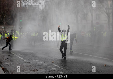 Paris, Frankreich. 19. Jan 2019. Demonstrant reagiert auf die Polizei Wasserwerfer bei einer Demonstration gegen den französischen Präsidenten Längestrich Politik. Gelbe weste Demonstranten versammelt und marschierten auf den Straßen von Paris ein weiteres Samstag auf, was Sie die Akte X gegen die Politik der französische Präsident Emmanuel's Längestrich nennen. Credit: SOPA Images Limited/Alamy leben Nachrichten Stockfoto