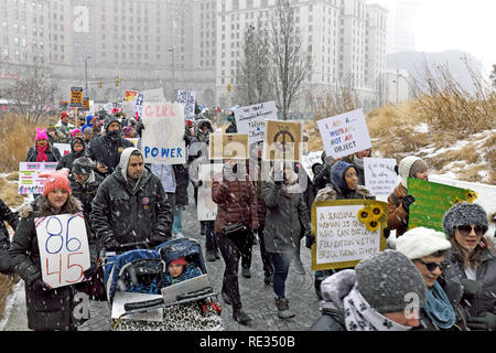 Cleveland, Ohio, USA, 19. Januar 2019. Gebündelt und trotzen die Elemente der Wintersturm Harper, Teilnehmer der 2019 Frauen März machen sich auf den Weg durch verschneite Öffentlicher Platz in der Innenstadt. Credit: Mark Kanning/Alamy Leben Nachrichten. Stockfoto